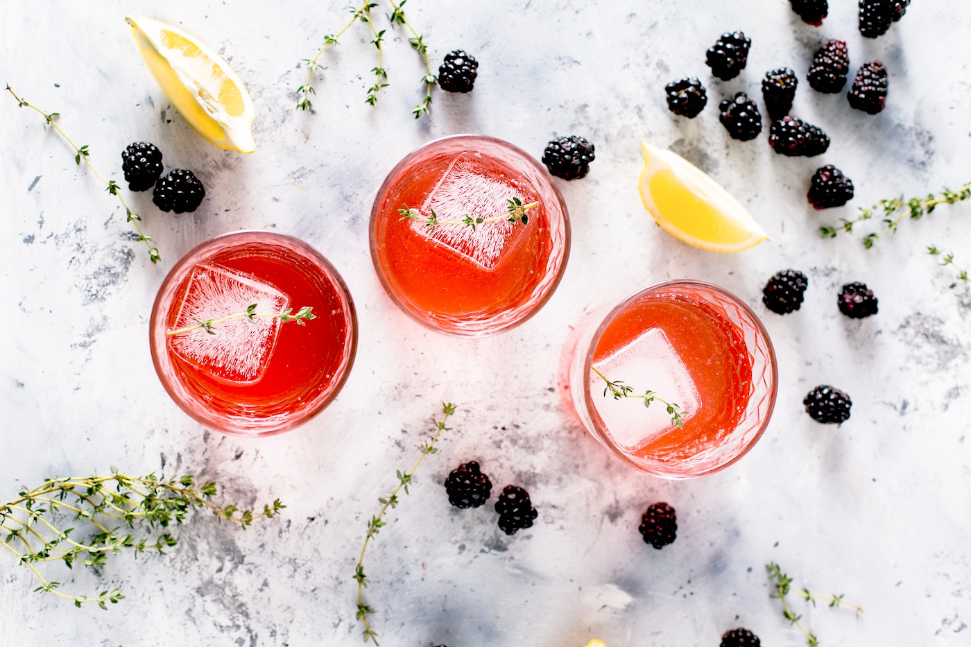 Red cocktails with blackberries around them